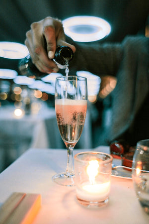 person putting champagne in champagne glass