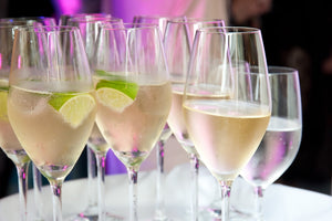 Champagne glasses with lime slices are displayed.