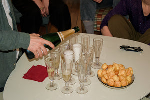 Champagne being poured into glasses with pastries.