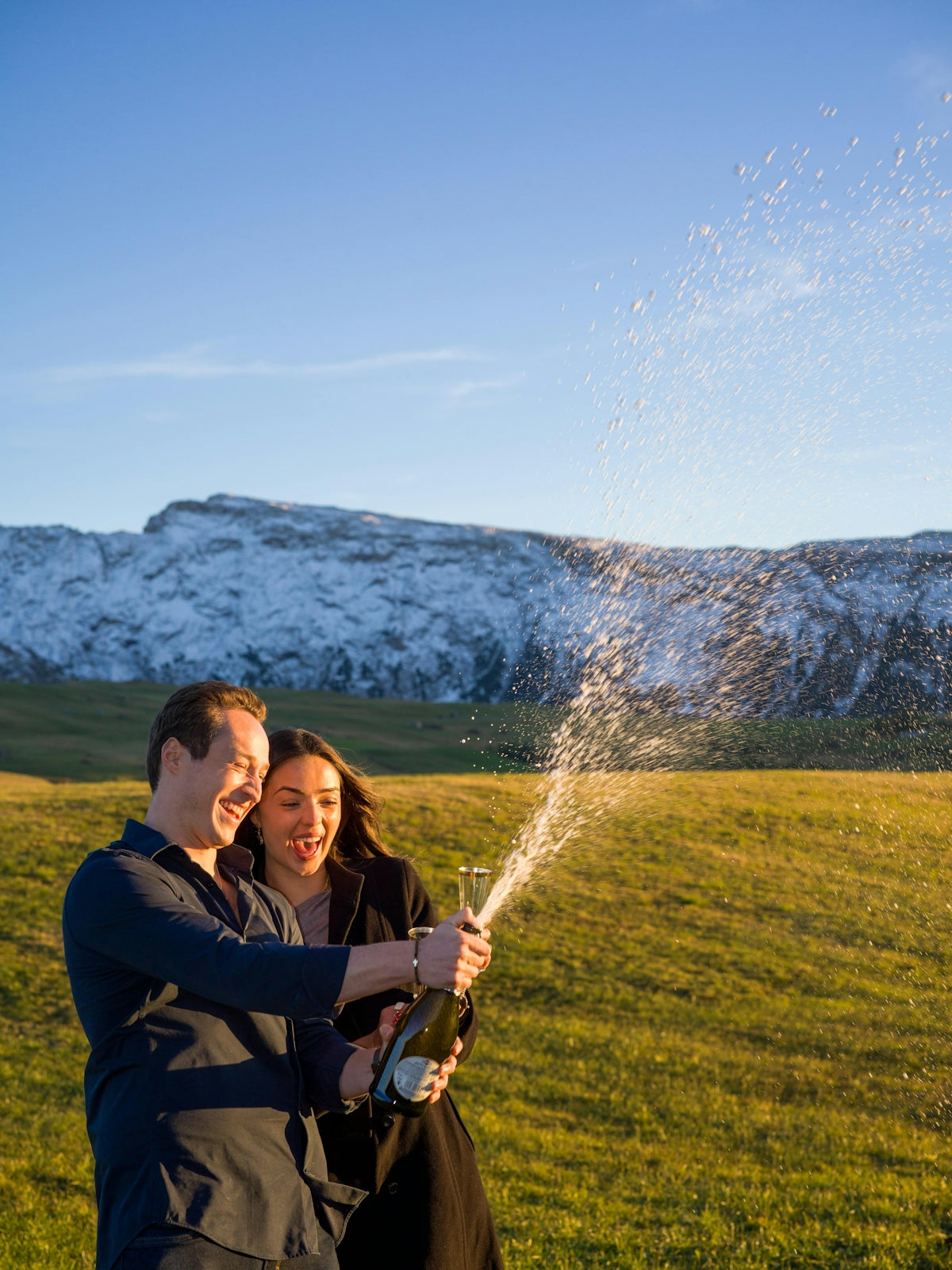 Couple celebrating with champagne outdoors